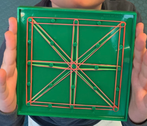 Uno studente mostra la sua opera: un quadrato con linee diagonali e che lo dividono a metà.