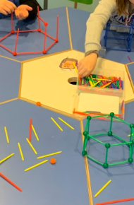 Bambine e bambini compongono figure tridimensionali unendo bastoncini incastrandoli in apposite sferette.