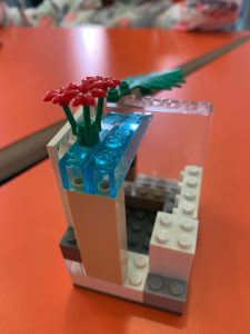 Costruzione in Lego, con alcune parti trasparenti sporgenti e dei fiori in cima.